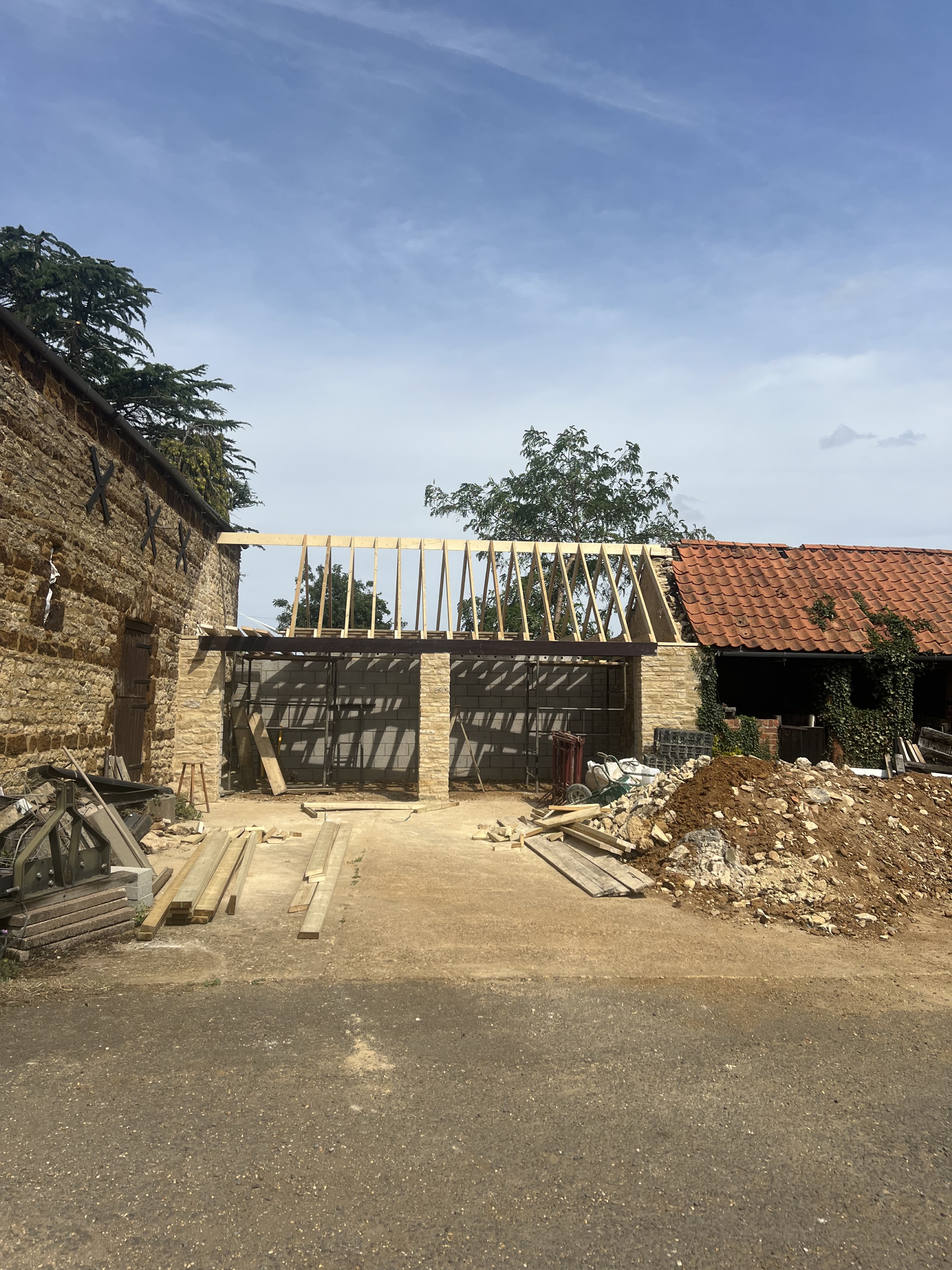 Open yard with new timber roof spanning outbuildings