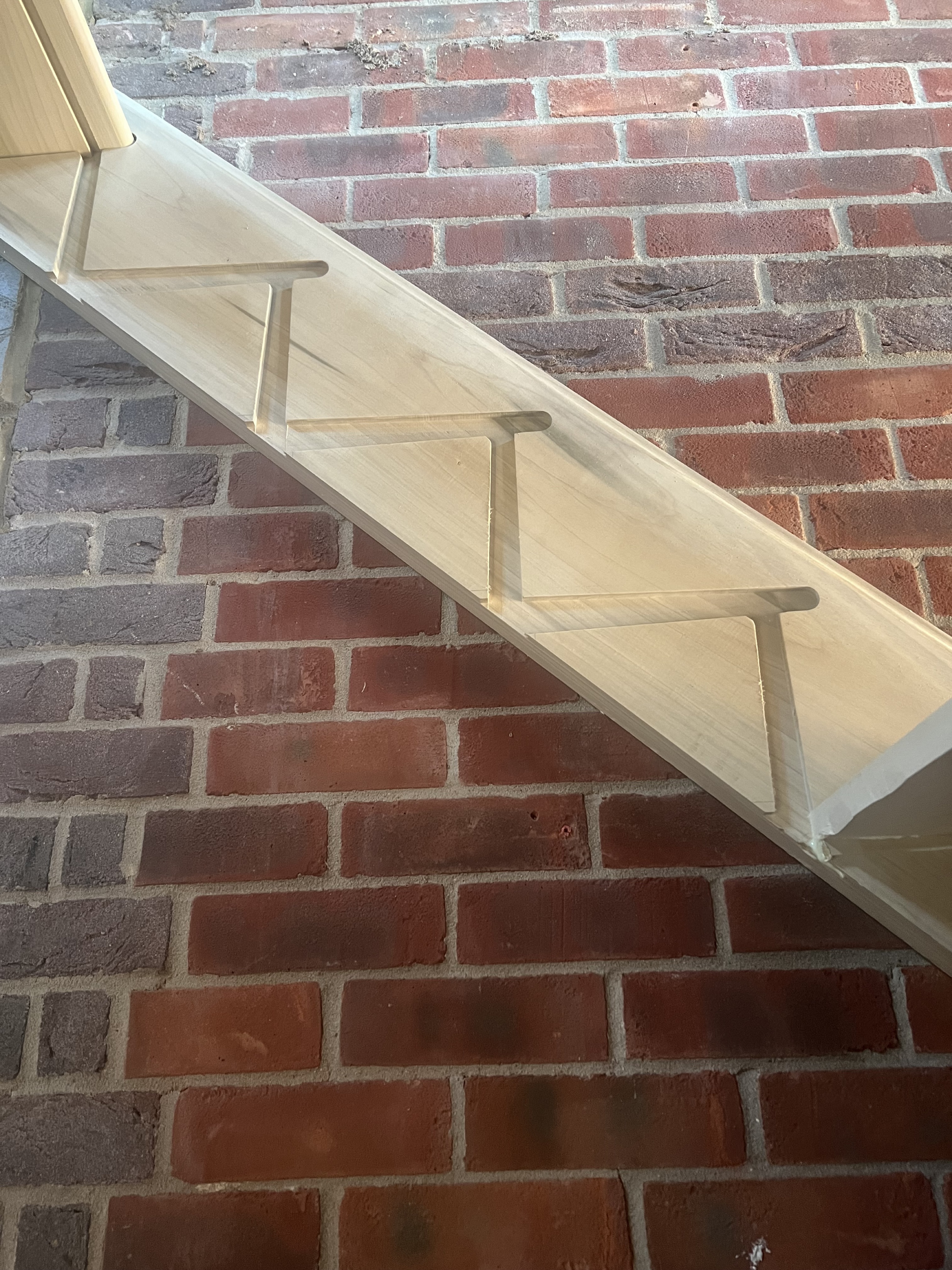 Close‑up of a timber stair stringer with zig‑zag cut‑outs ready for treads